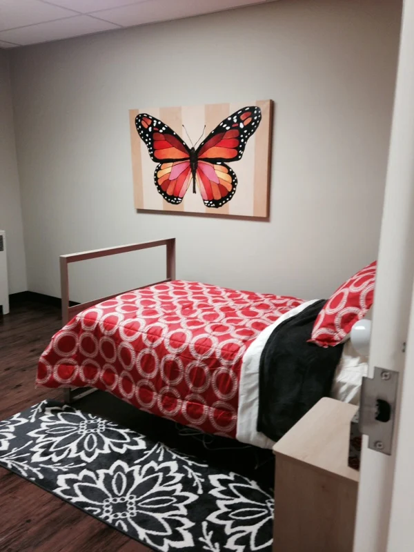 Private bedroom with butterfly art and red bedding