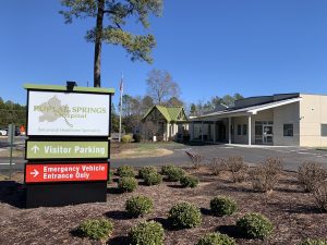 Facility sign near landscaped hospital entrance