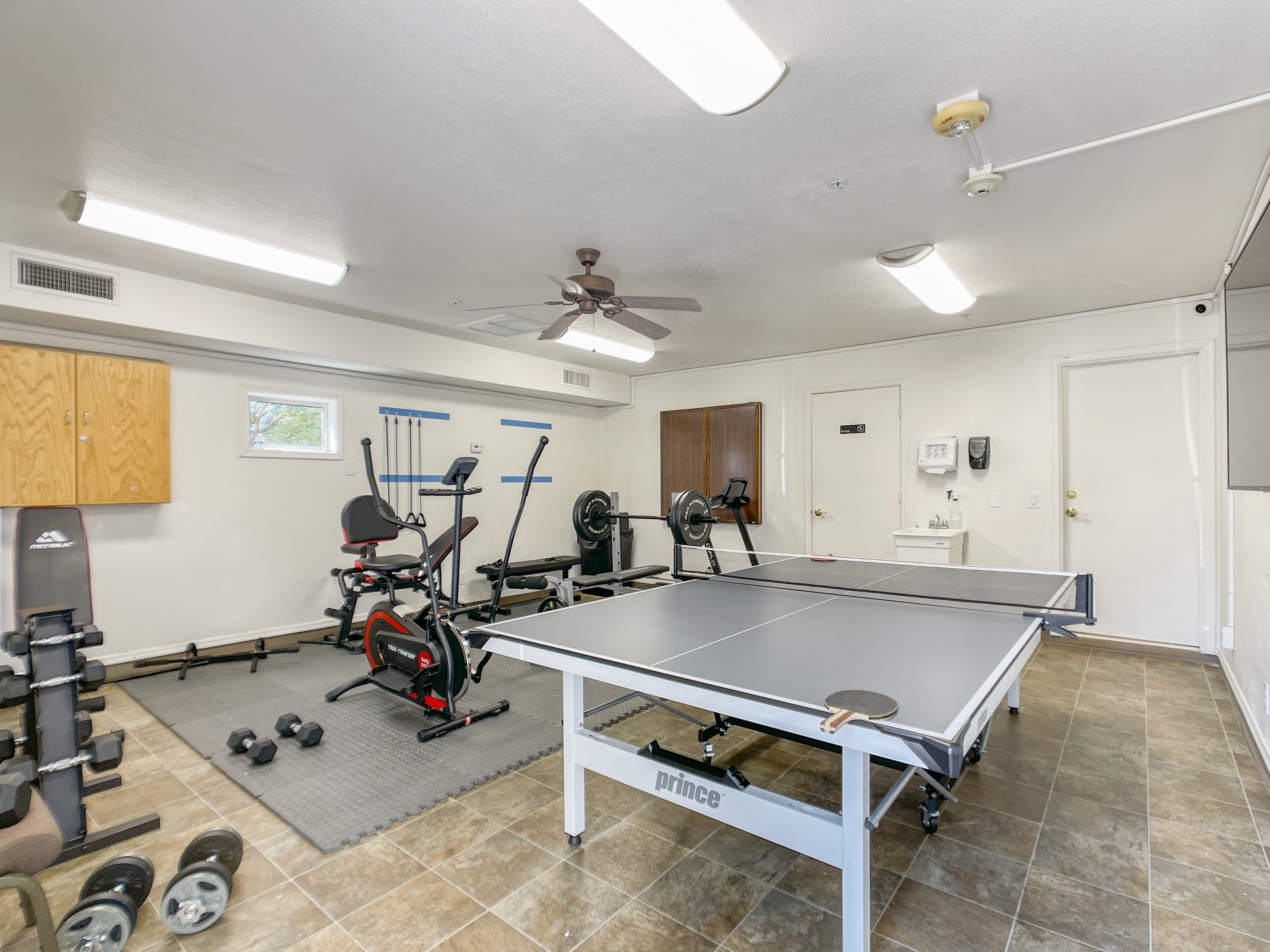 Recreational room with gym equipment, a ping-pong table.