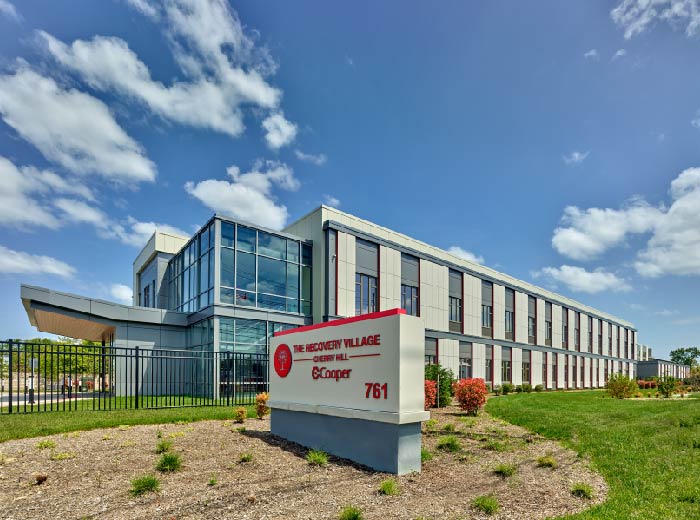 Street view of building exterior with signage and lawn.