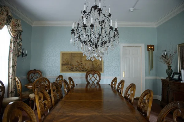 Long wooden table with ornate chairs and chandelier