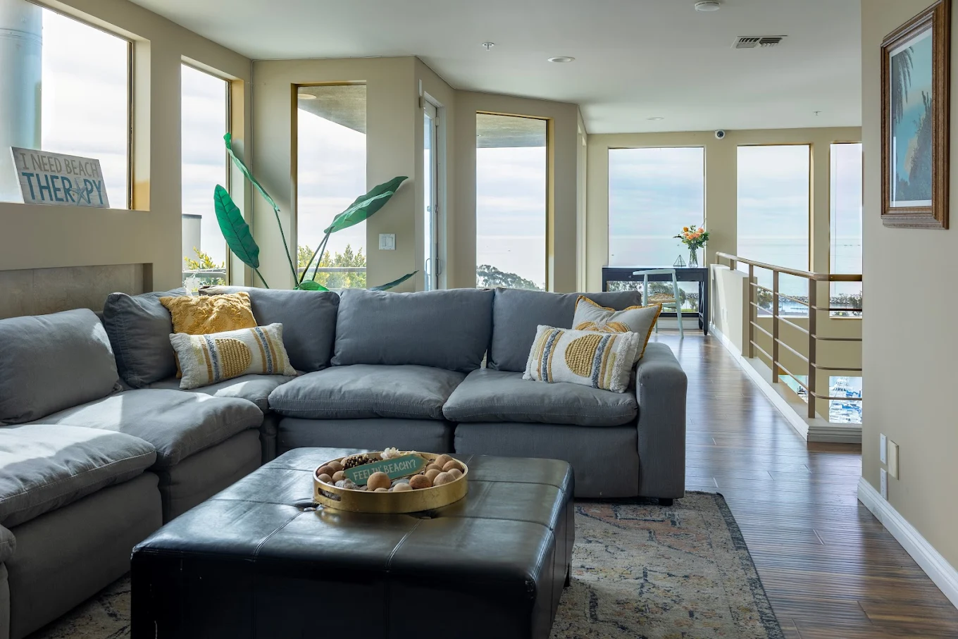 Lounge with gray sofa and ocean view through large windows