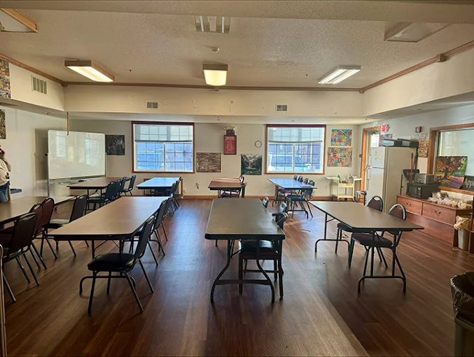 Meeting room with tables, chairs, and whiteboard