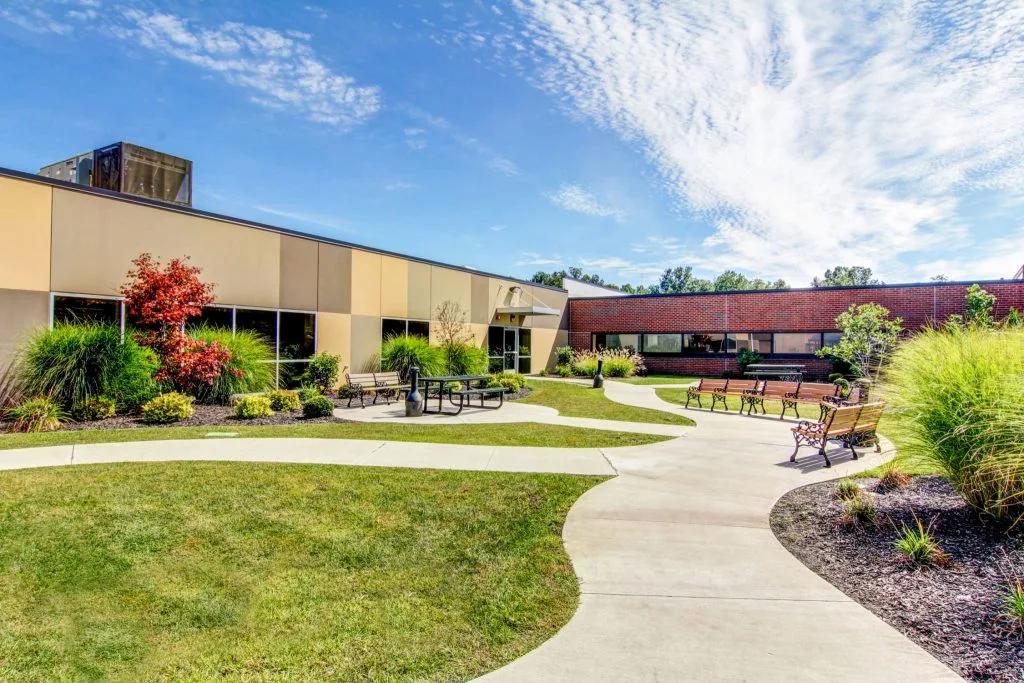 Landscaped courtyard with walking paths, benches, and tables.