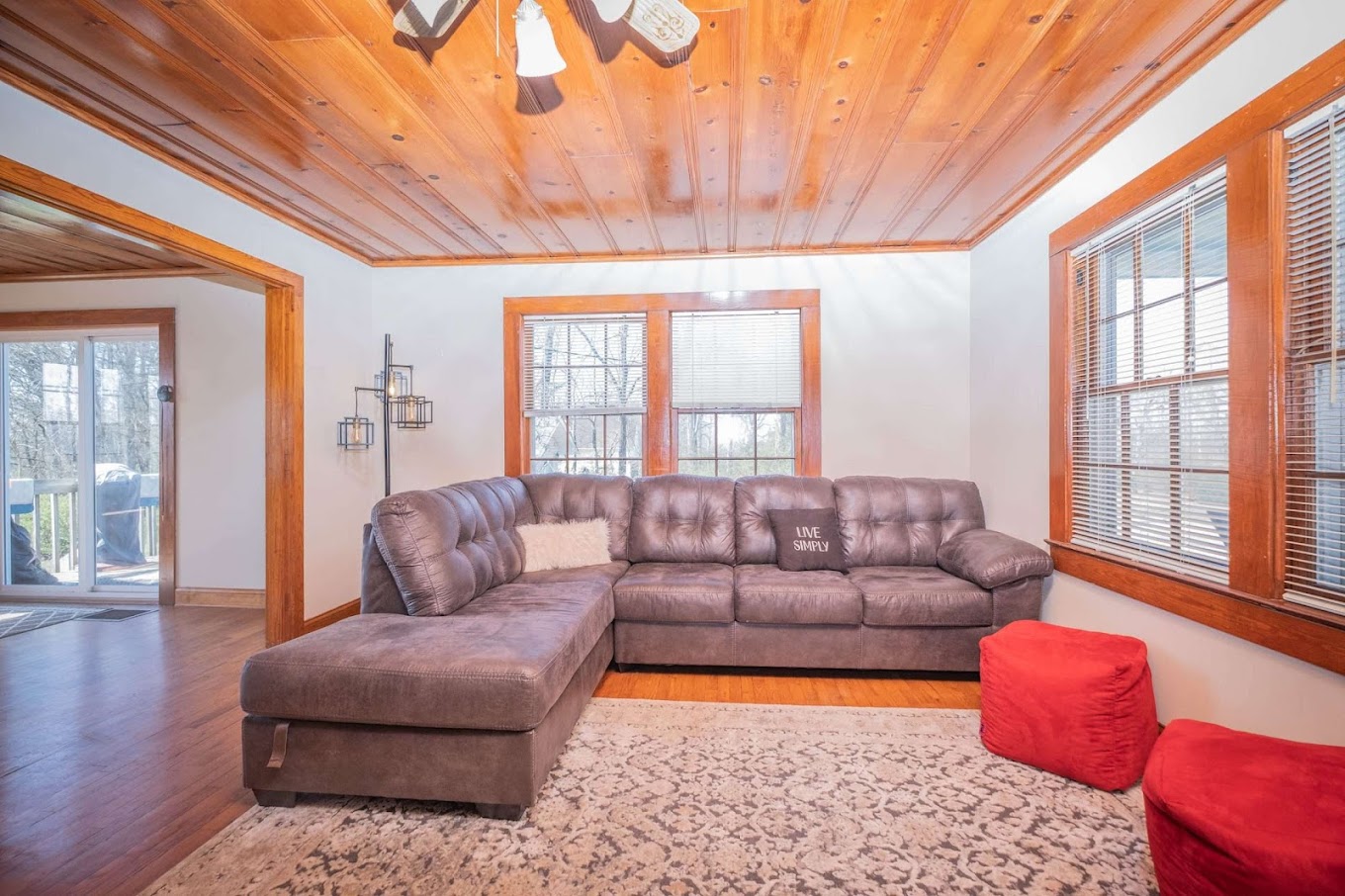 Living room with a gray sectional couch and wooden ceiling.