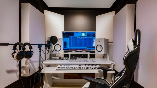 Professional music studio setup with recording equipment, keyboard, and soundproof panels
