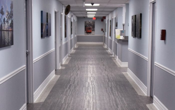 Long hallway lined with doors and framed artwork