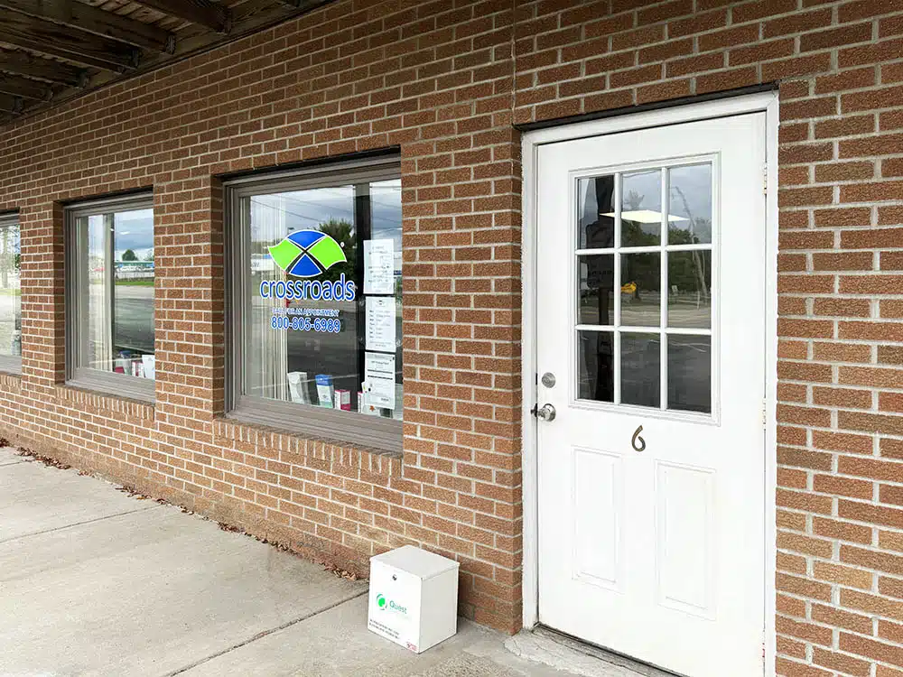 Brick exterior with Crossroads window sign and door number