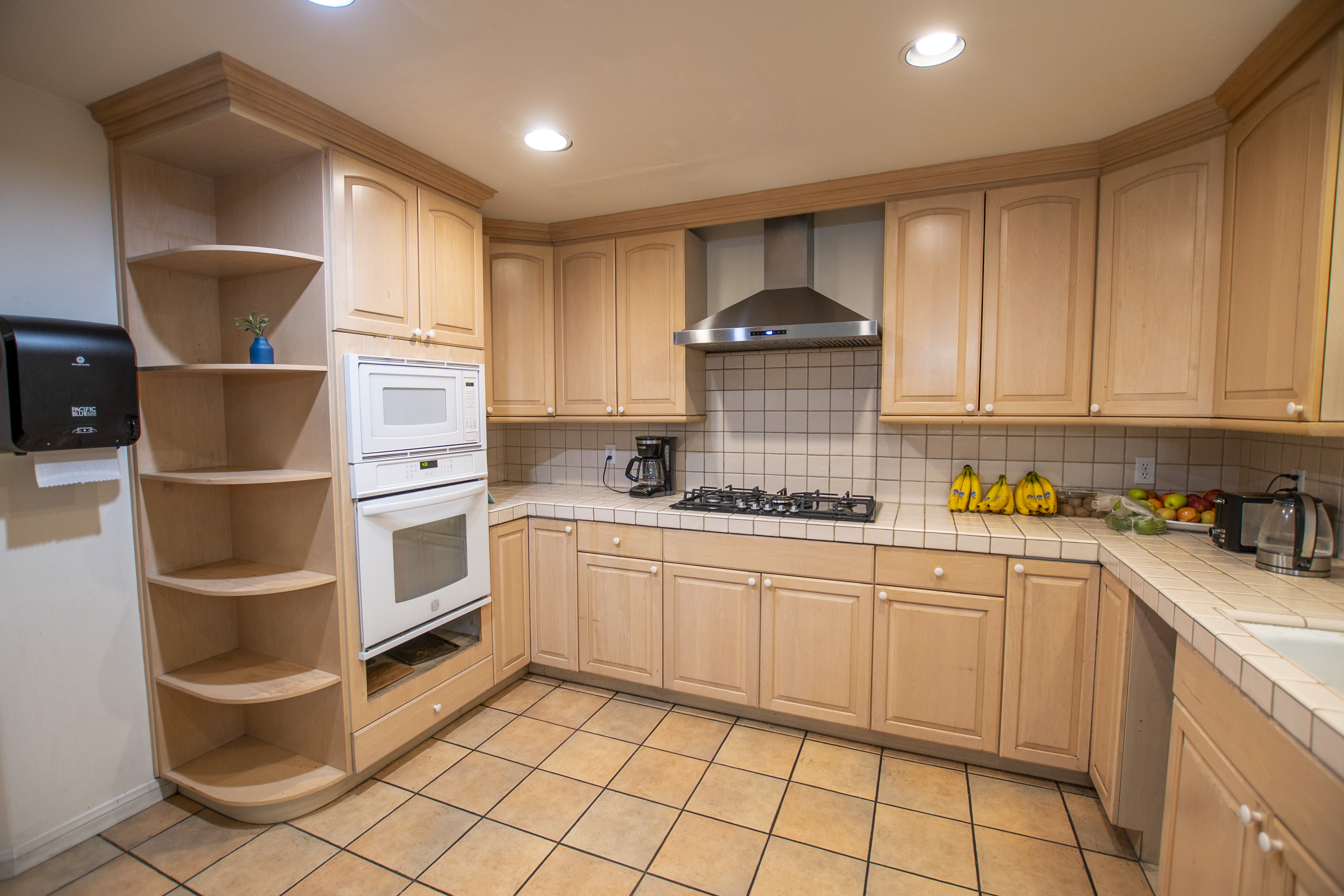 Full kitchen with light wood cabinets and gas range