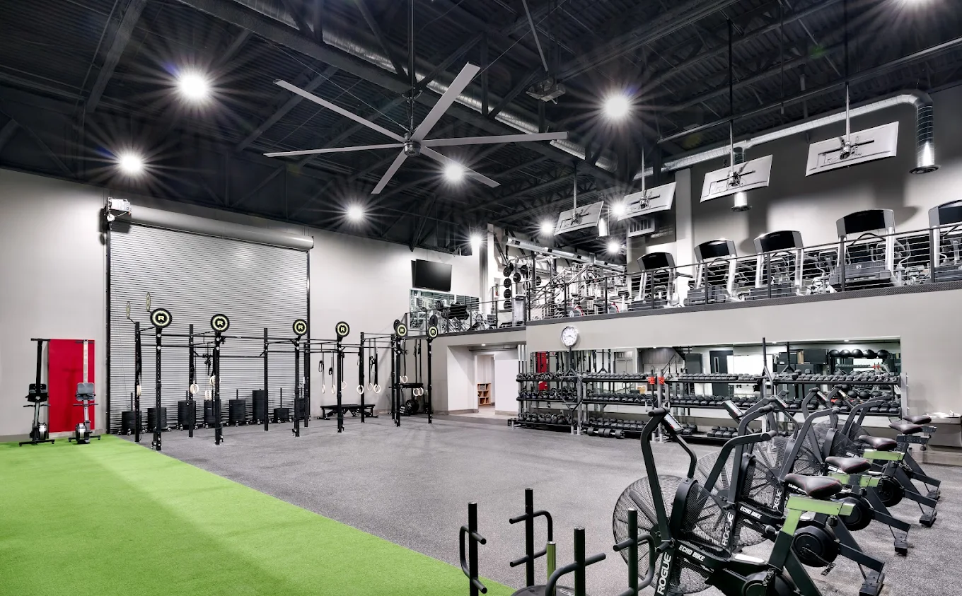 Spacious gym with treadmills, weights, and bright lighting