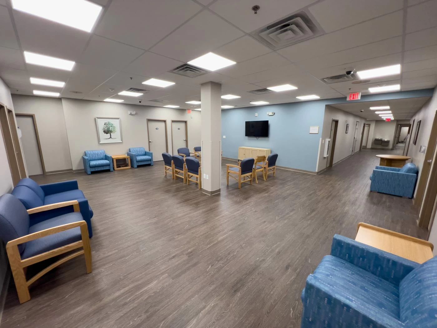 Open residential common area with seating and television inside treatment facility
