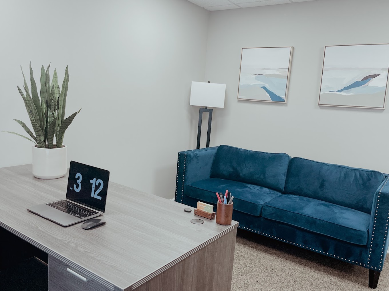 Cozy office space with a blue couch and desk.