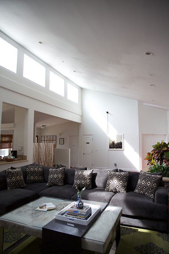 Spacious lounge with sectional sofa and high windows