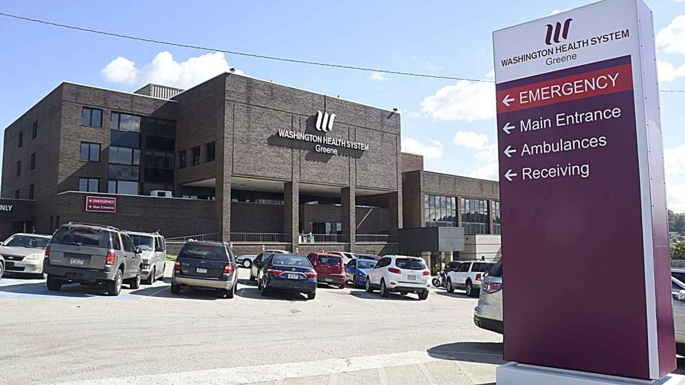Hospital building with parking lot and emergency sign
