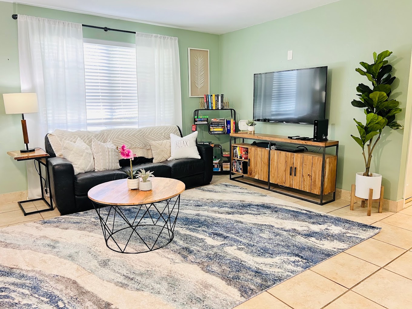 Cozy living room with couch, TV, and bookshelves.