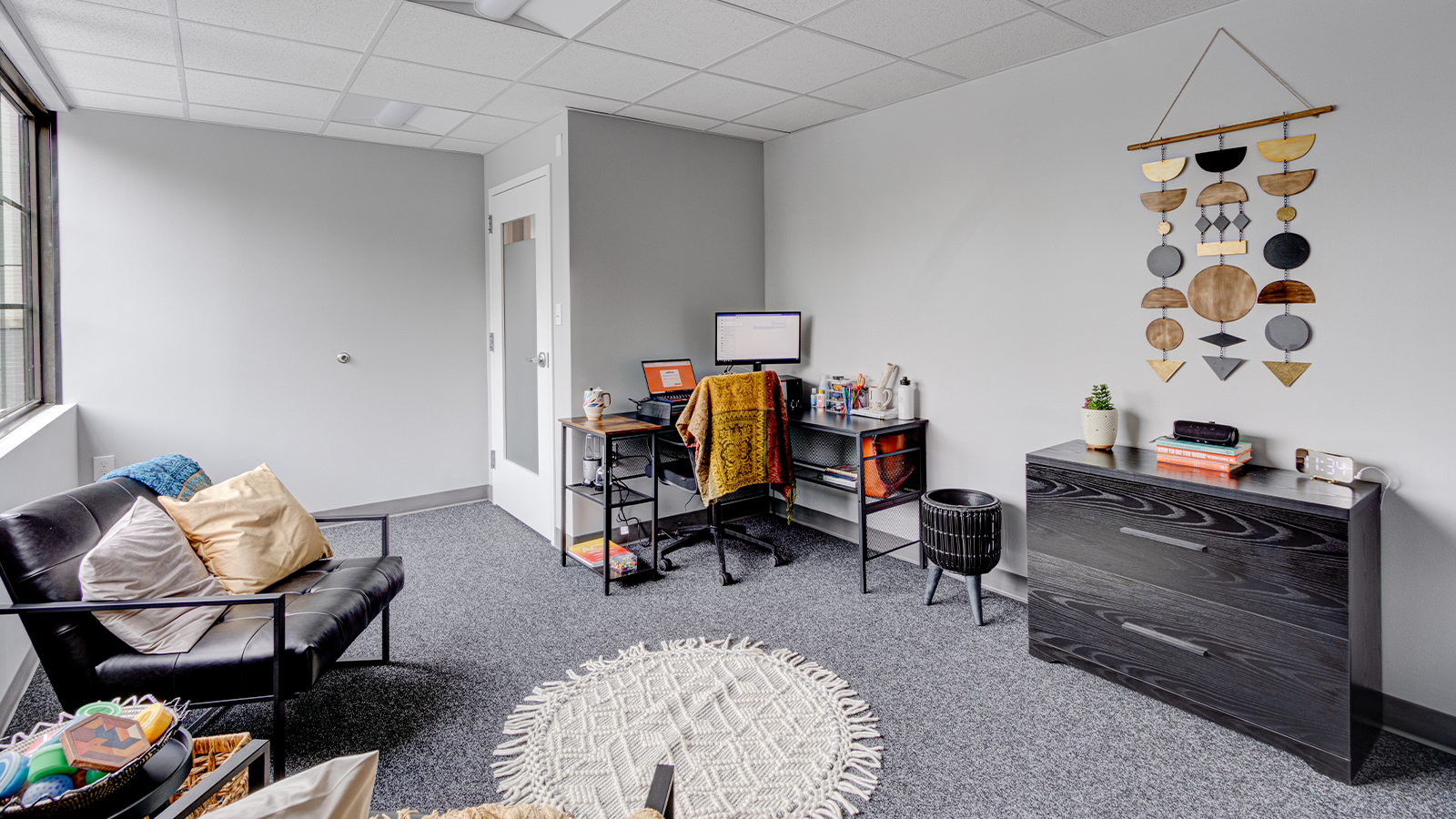 Therapy room with chairs, desk and decor.