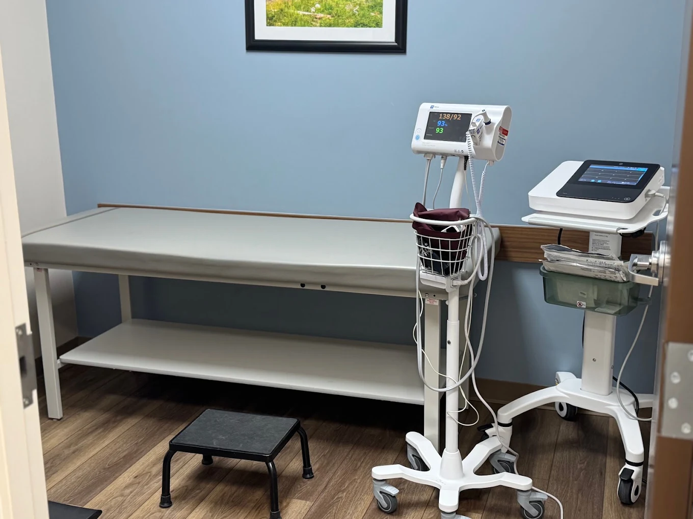 Medical room with exam table, vital signs monitor, and clinical equipment