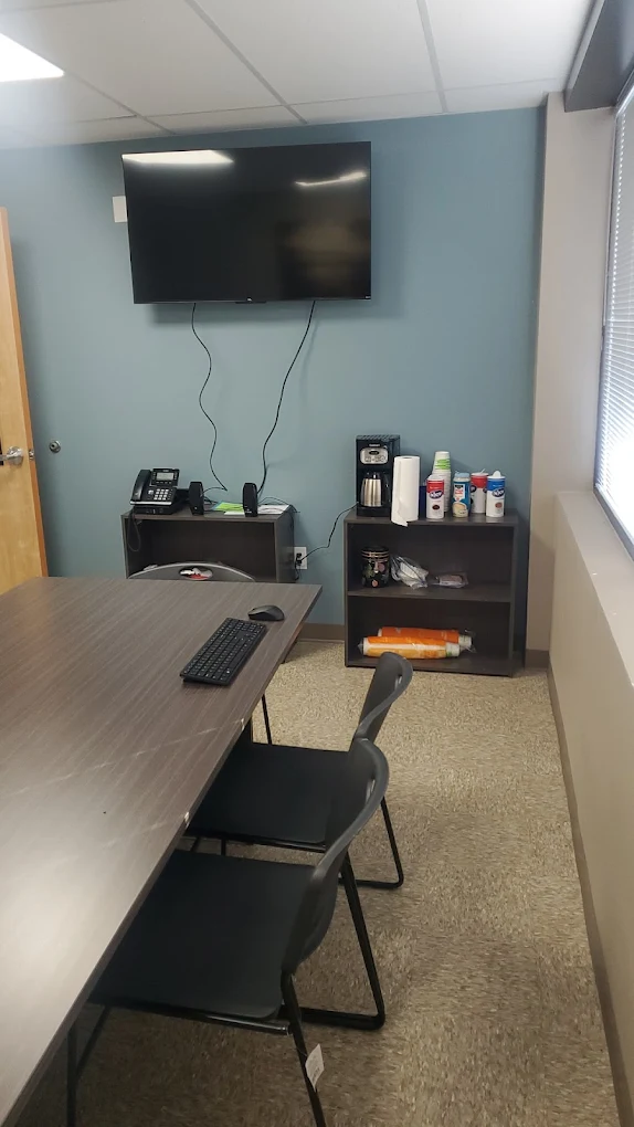 Meeting room with TV, workstation, and coffee station