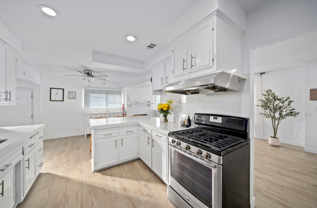 Spacious kitchen with white cabinets and stainless-steel stove