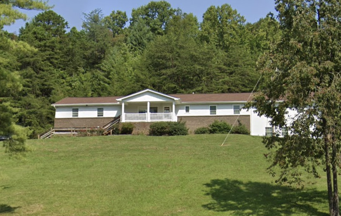 Front exterior of Independence House with lawn and surrounding trees