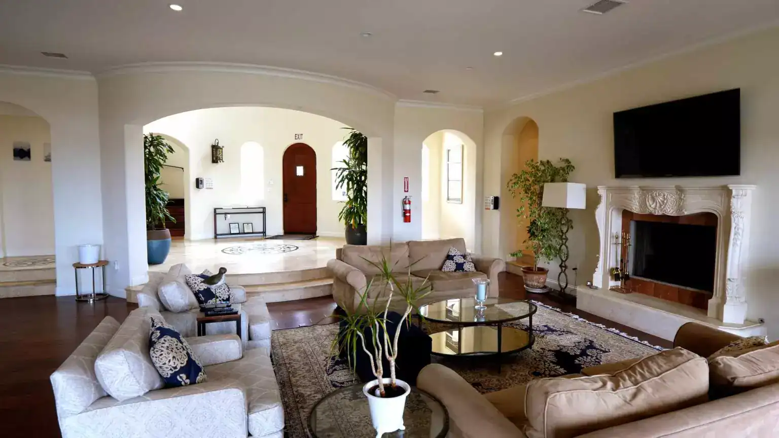 Spacious living room with sofas, fireplace, and wall-mounted TV