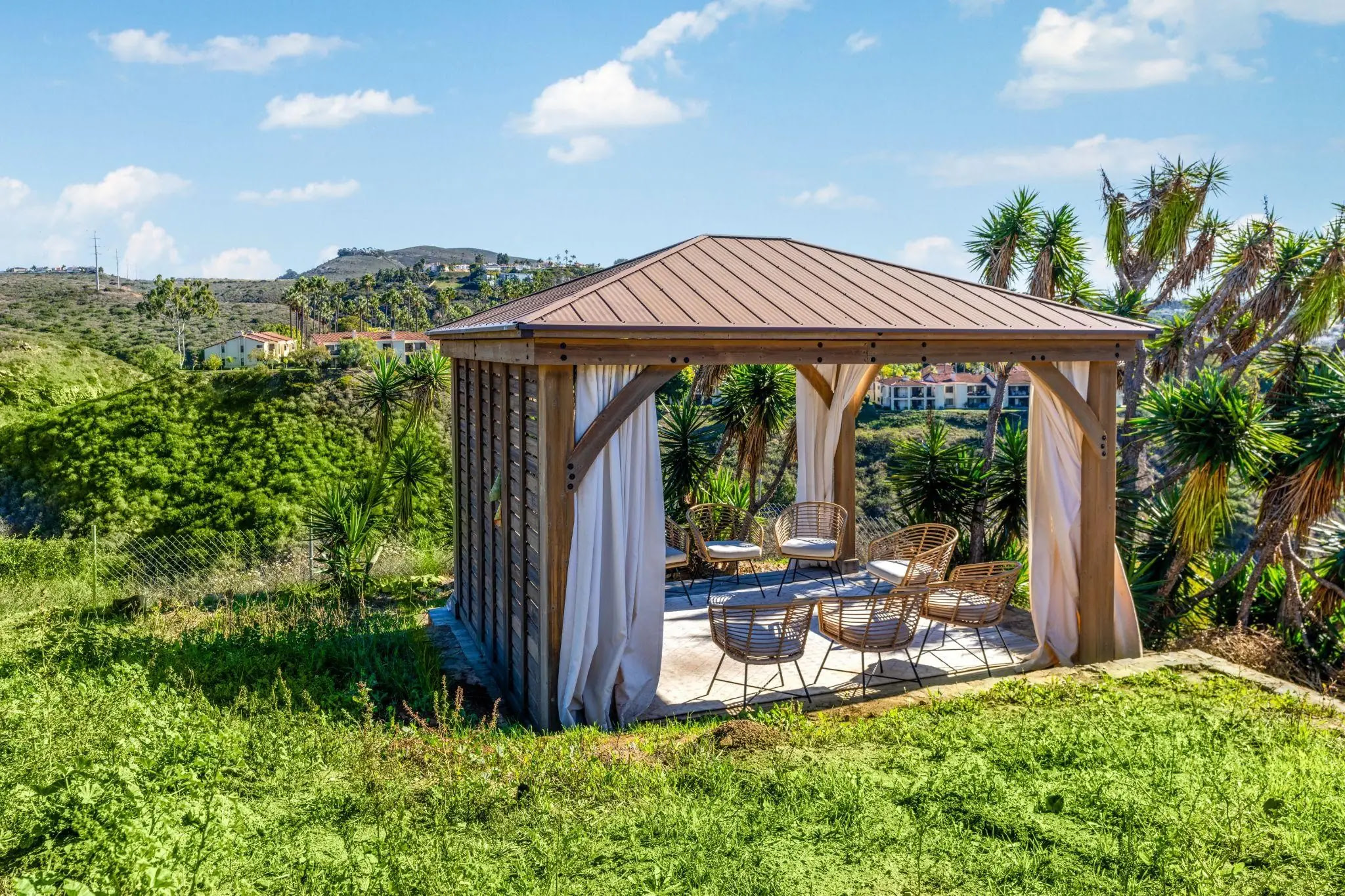 Hilltop gazebo with wicker seating and scenic valley views