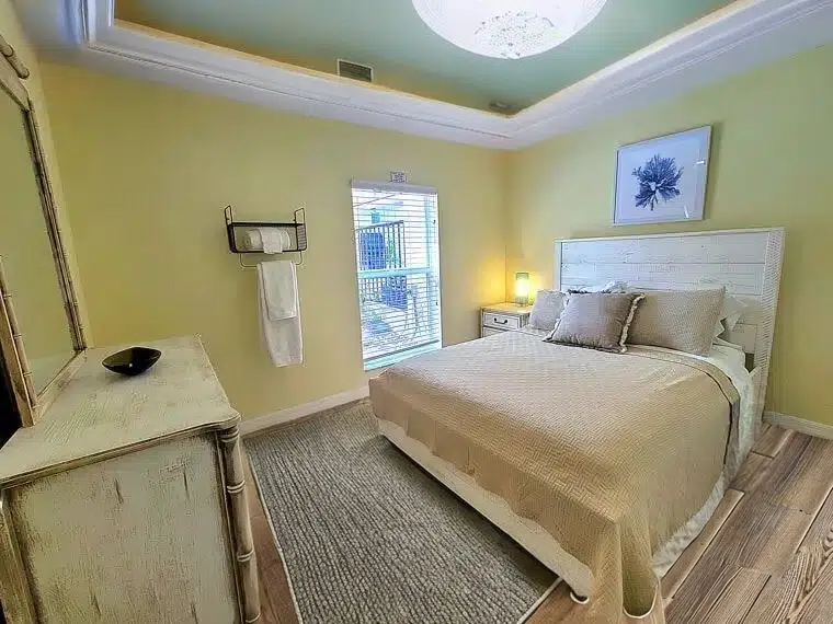 Private bedroom with a bed, dresser with a mirror, and a window.