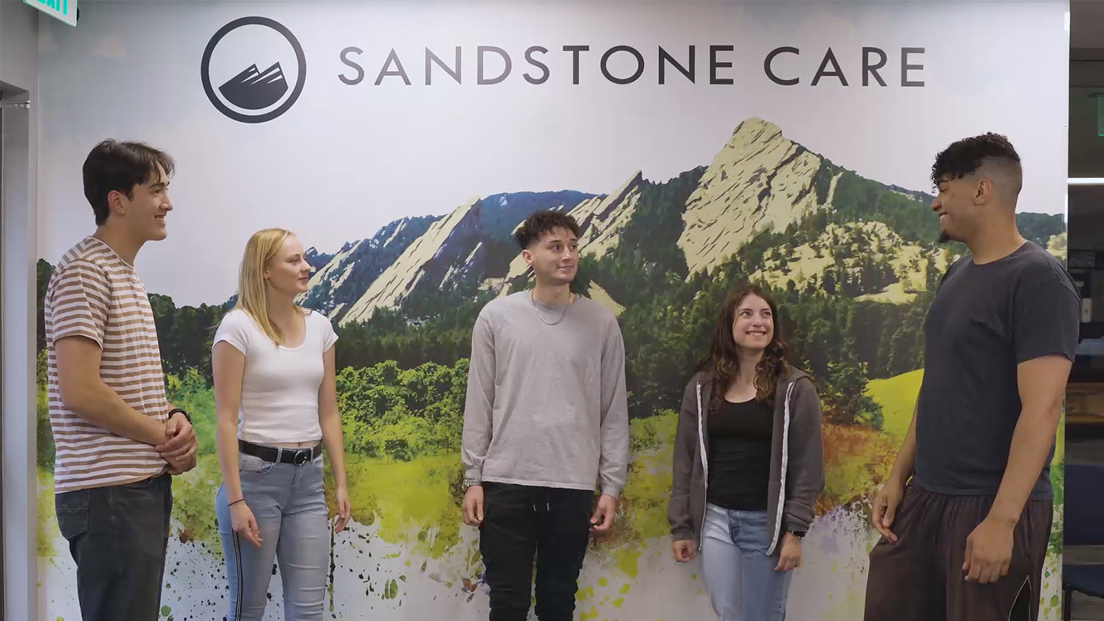 A group standing  in front of Sandstone Care backdrop.