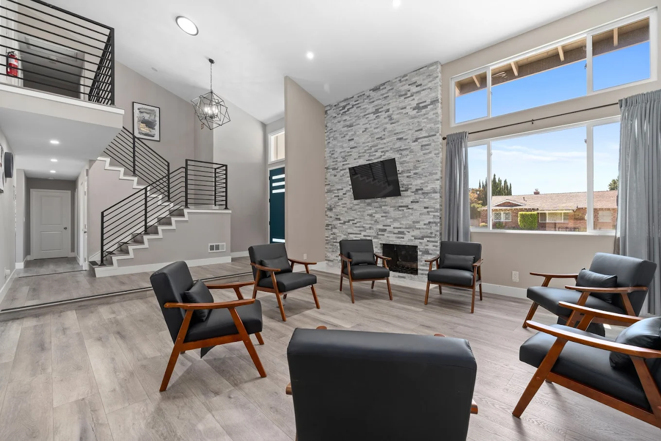 Circle of chairs in open room with large windows