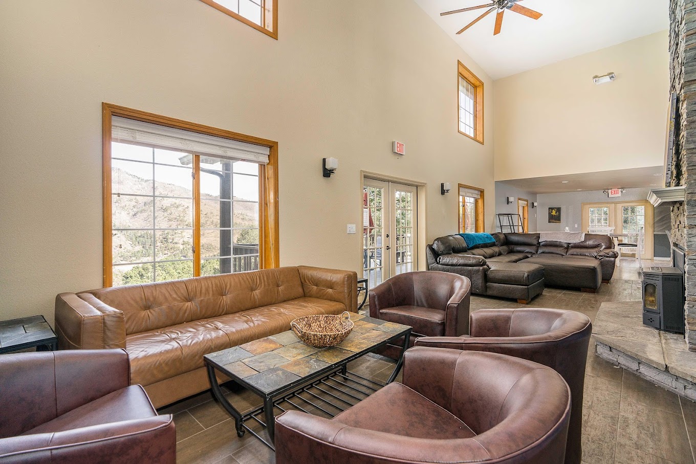 Living room with  leather seating, and a stone fireplace.