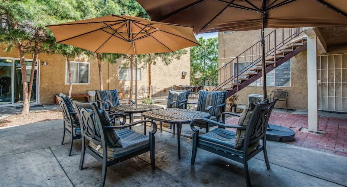 Outdoor patio with tables, chairs, and umbrellas