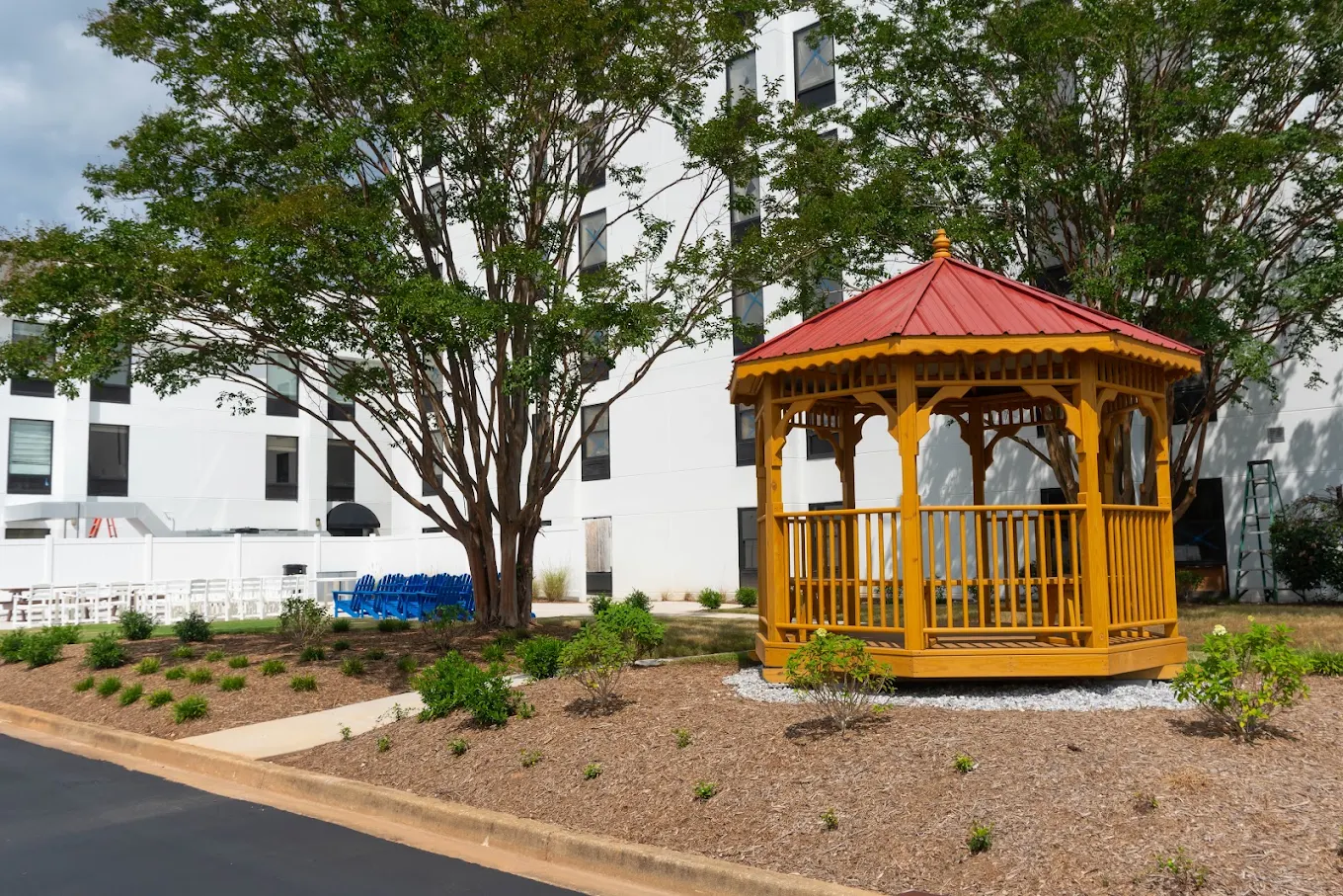 Wooden gazebo surrounded by trees and landscaped grounds