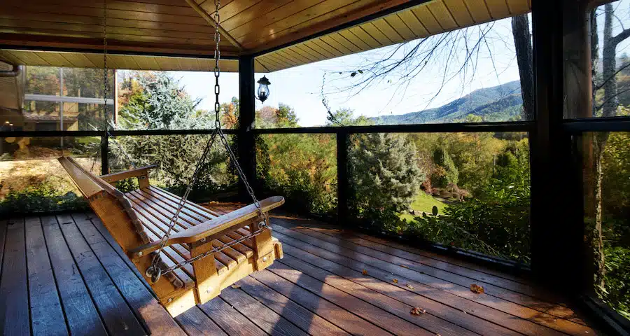 Covered patio with wooden swing and mountain views
