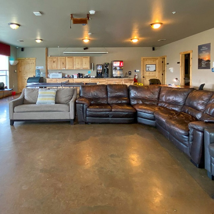 Lounge with leather couches and kitchen in background