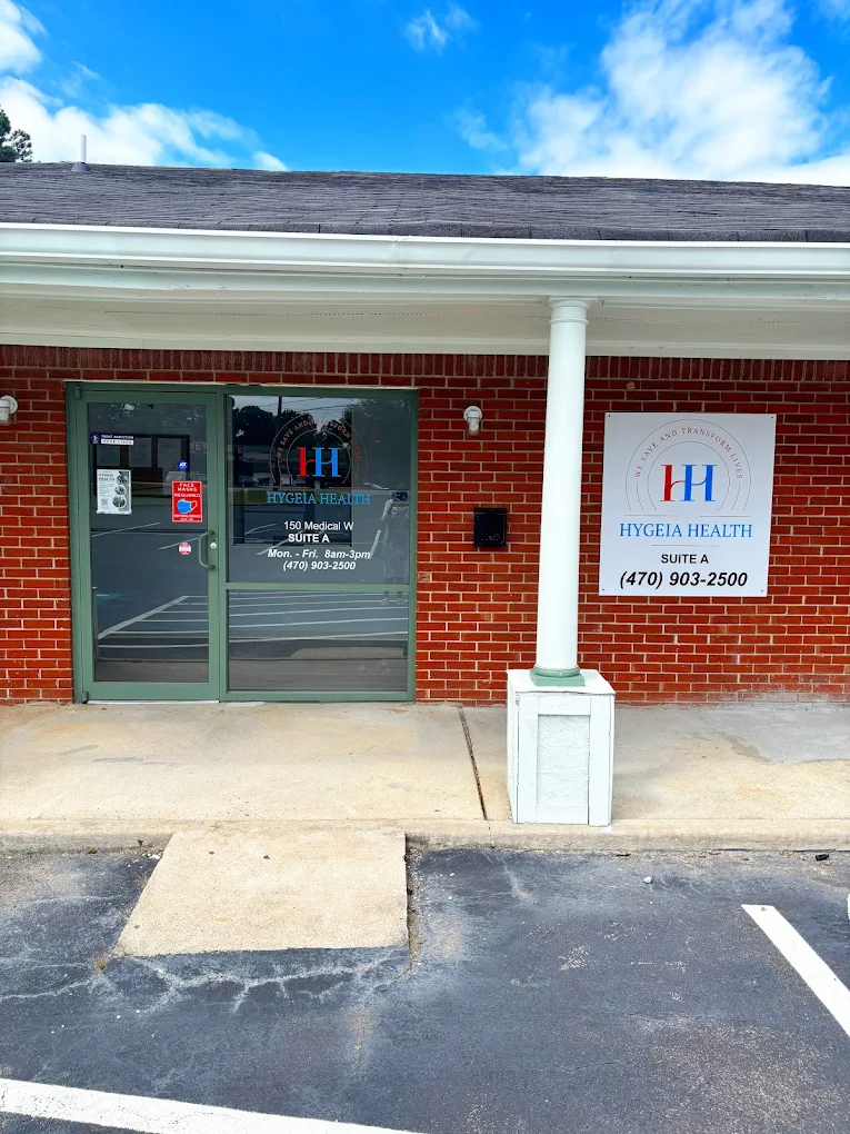 Brick building entrance with glass doors and white columns
