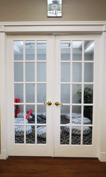 Soft-lit space with poufs behind glass doors