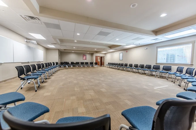 Spacious group therapy room with chairs arranged in a large circle