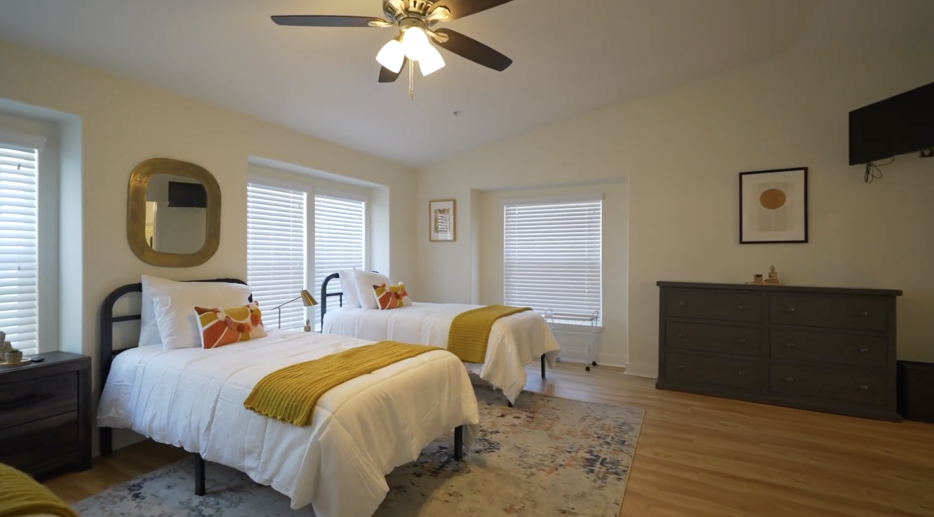 Shared bedroom with two beds, dresser, and natural light