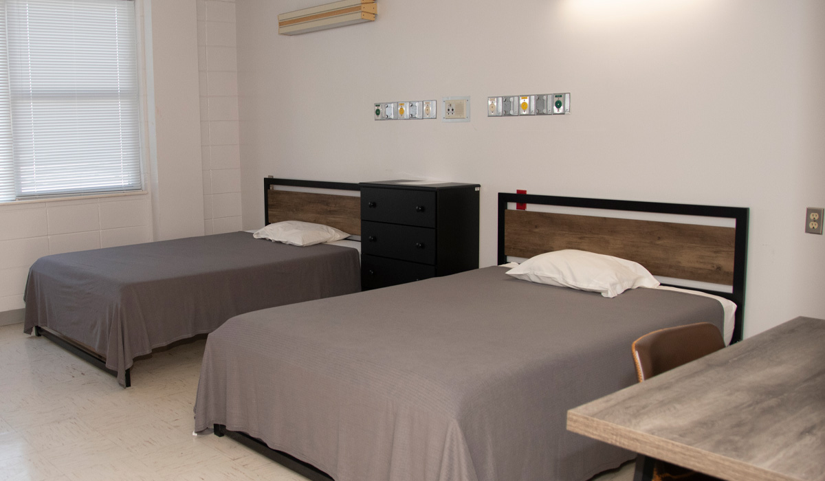 Shared bedroom with two twin beds and a dresser.