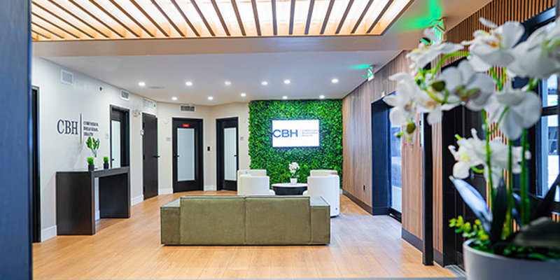 A modern reception area with a sleek design, vibrant greenery wall, and comfortable seating, creating a welcoming and professional environment.