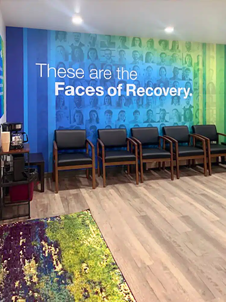 Faces of Recovery wall and seating in rehab waiting area