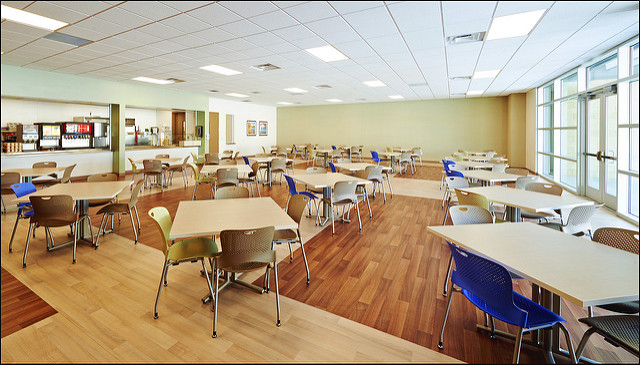Spacious rehab cafeteria with tables and drink station