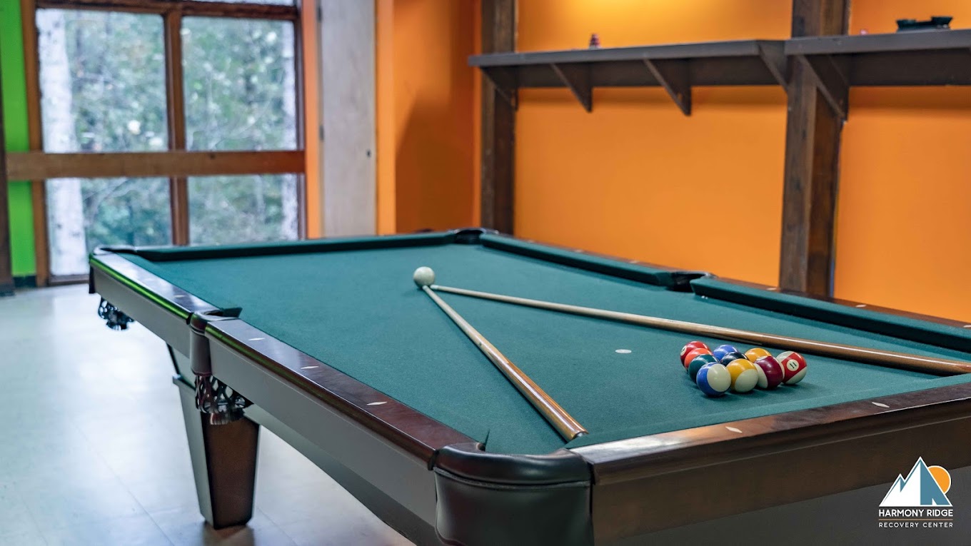 A pool table with cues and billiard balls in a recreation room
