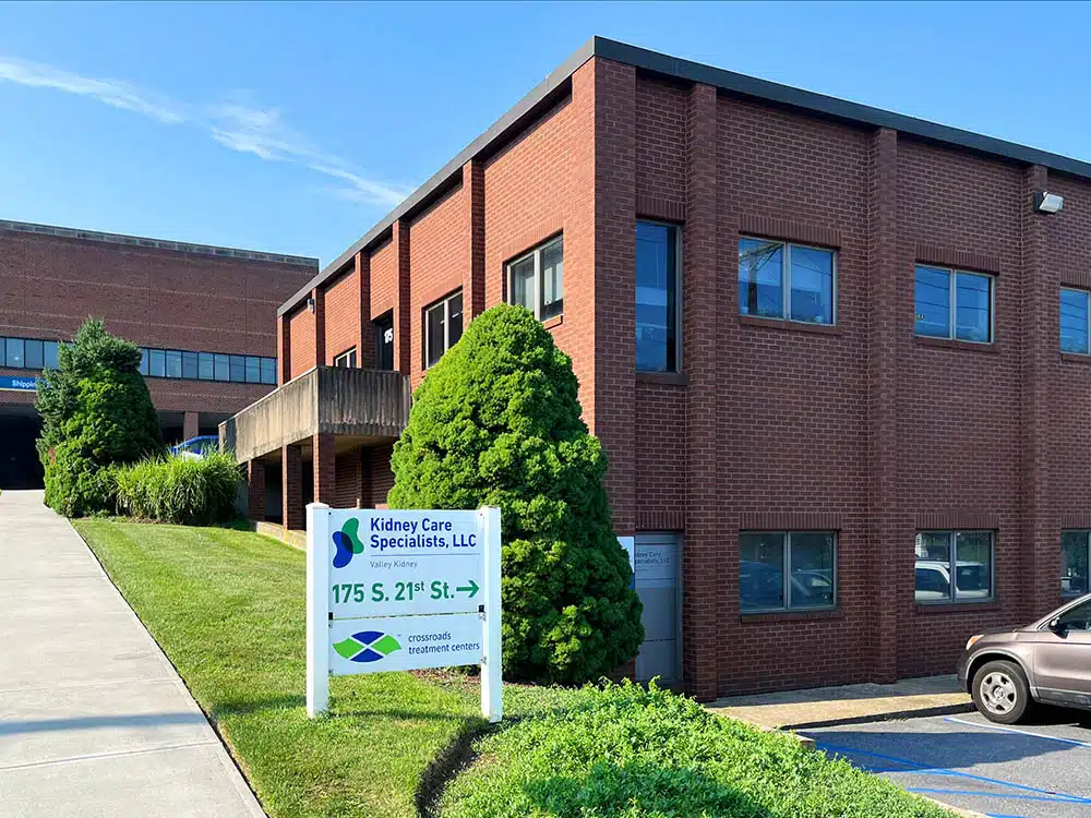 Brick office building with Crossroads sign and parking