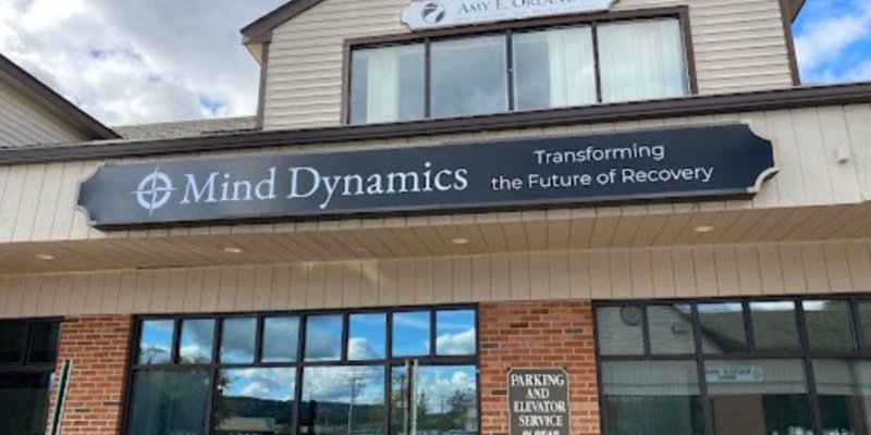 Mind Dynamics' building exterior features a modern sign reading “Transforming the Future of Recovery” with accessible parking in view.