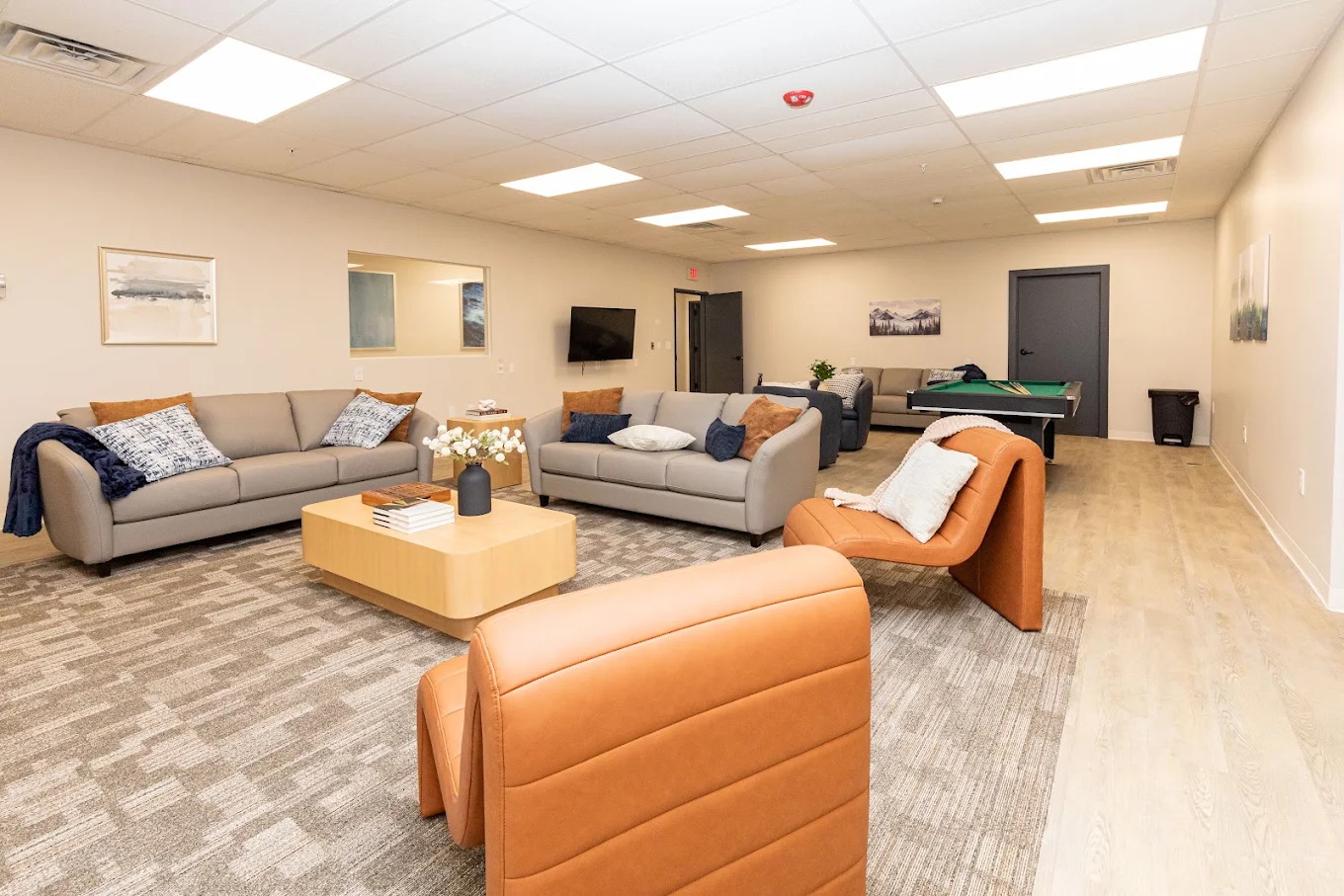 Spacious common area with sofas, chairs, and television