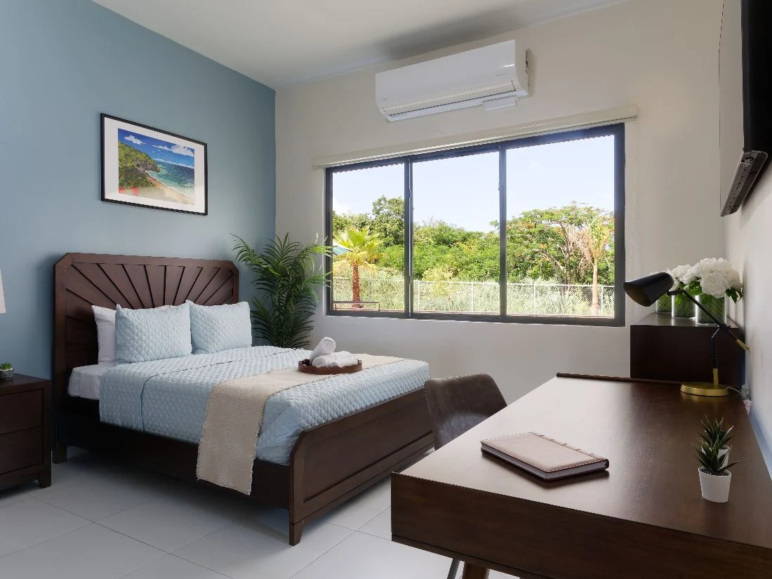 Private bedroom with large bed, desk, and garden view