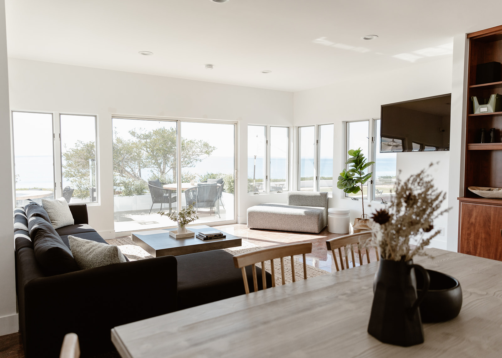 Bright living space with ocean views, modern furniture, and natural decor.