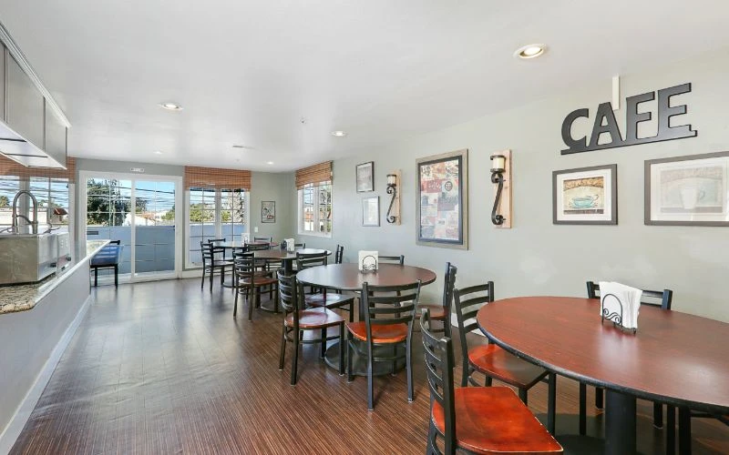 Casual dining space with round tables and “CAFE” wall decor