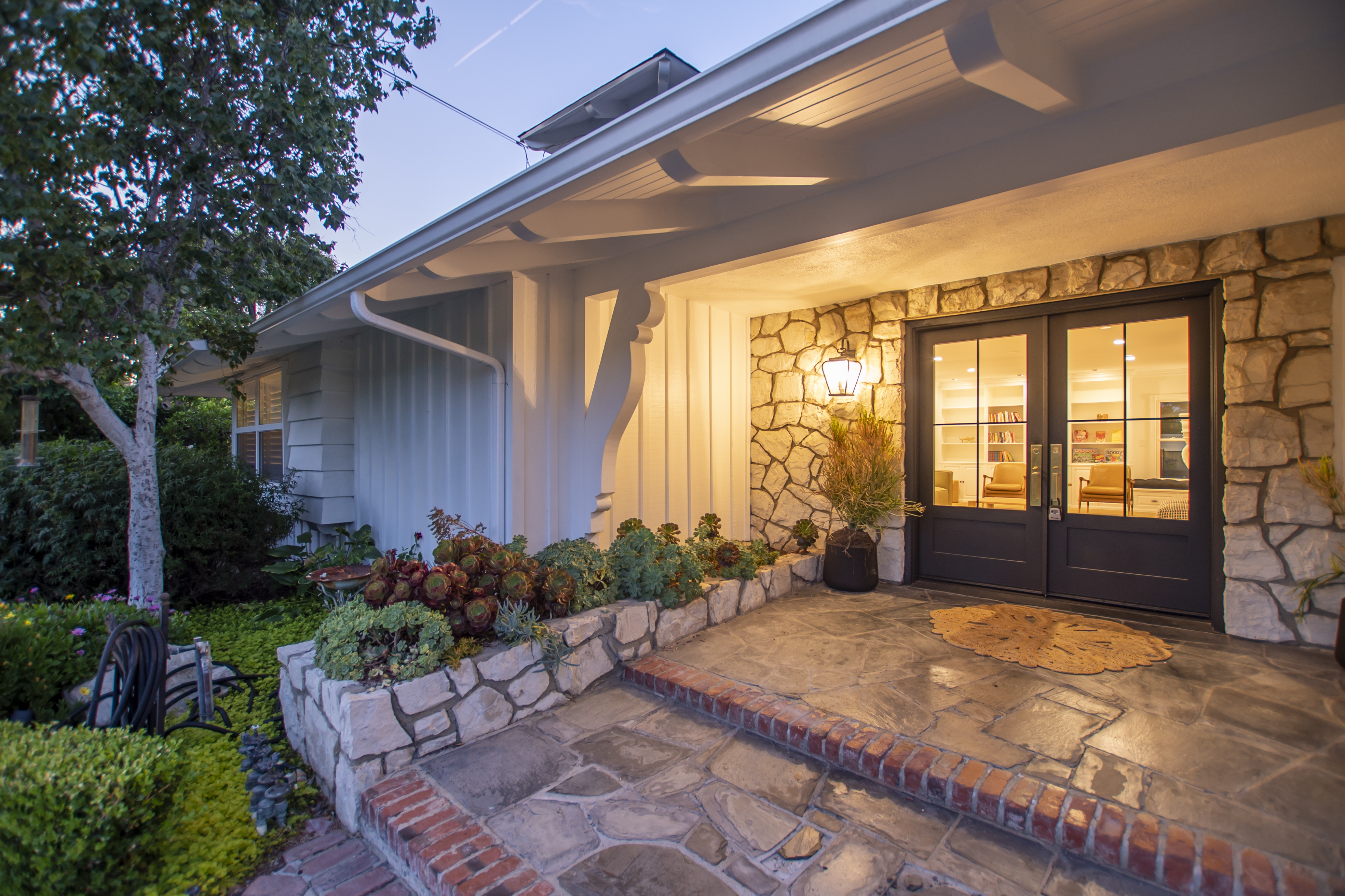 A warmly lit facility entrance with stone walls and double doors.